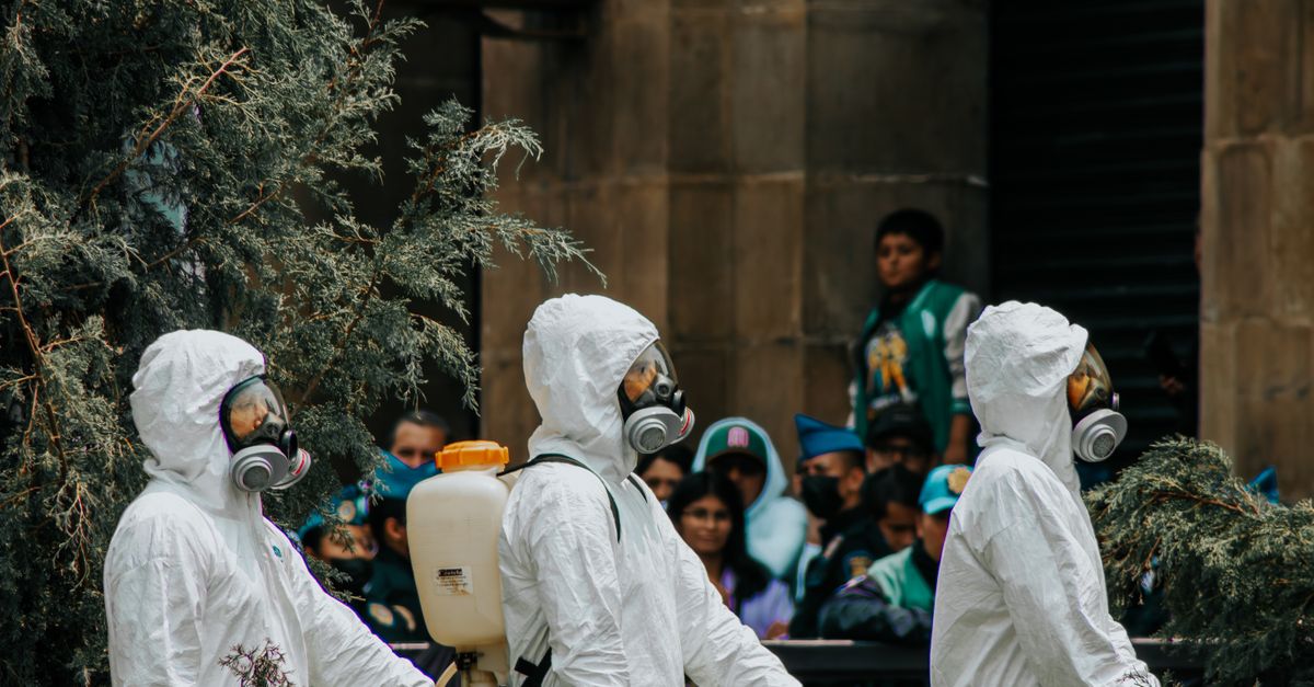 People wearing protective suits and masks in a parade in Mexico City.
